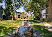 Thumbnail 32 of 42 - a stream runs through a grassy area between two apartment buildings