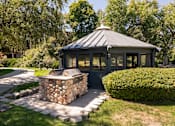 Thumbnail 28 of 42 - a gazebo in the backyard of a house with a stone fire pit