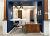 Thumbnail 41 of 42 - an office with a desk and a chair and a blue wall
