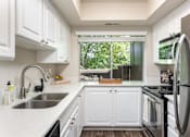 Thumbnail 5 of 42 - a kitchen with white cabinets and a sink and a window