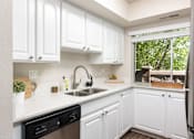 Thumbnail 6 of 42 - a kitchen with white cabinets and a sink and a window