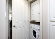 Thumbnail 12 of 42 - a white washer and dryer in a small laundry room