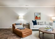 Thumbnail 2 of 42 - a living room with a couch and a chair and a table