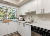 Thumbnail 19 of 42 - a kitchen with white cabinets and a sink and a window