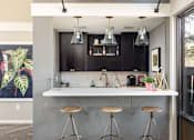 Thumbnail 28 of 38 - a kitchen with a counter and bar stools