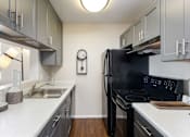 Thumbnail 5 of 38 - a kitchen with black appliances and white counter tops