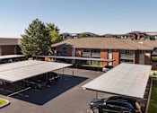 Thumbnail 36 of 38 - a roofed parking lot in front of a building