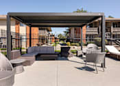 Thumbnail 20 of 38 - a lounge area with couches and chairs under a shade