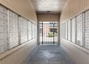 Thumbnail 35 of 38 - a long hallway with mailboxes and a gate