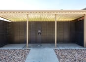 Thumbnail 34 of 38 - the outside of a building with a covered area and a door
