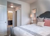 Thumbnail 8 of 42 - a bedroom with a bed and a door to a bathroom