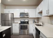 Thumbnail 15 of 42 - a kitchen with stainless steel appliances and white cabinets