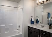 Thumbnail 20 of 42 - a bathroom with a shower and a sink and a mirror