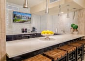 Thumbnail 31 of 42 - a kitchen with a long counter and a bowl of fruit