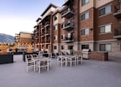 Thumbnail 41 of 42 - a patio with tables and chairs in front of an apartment building