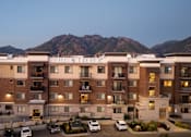 Thumbnail 36 of 42 - a large hotel with mountains in the background