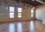 Thumbnail 7 of 16 - A room with wooden floors and a brick wall,Kassenborg Apartments, Moorhead,