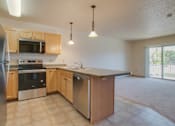 Thumbnail 2 of 16 - A kitchen with wooden cabinets and stainless steel appliances, Kassenborg Apartments, Moorhead, MN