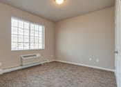 Thumbnail 3 of 12 - A room with a window and a wall-mounted air conditioner.