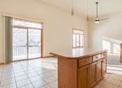 Thumbnail 3 of 10 - A kitchen with a wooden counter and tile floor.