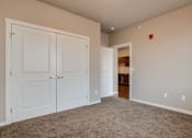 Thumbnail 4 of 12 - A room with white doors and a carpeted floor.