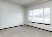 Thumbnail 4 of 13 - Empty room with a window overlooking a residential area.