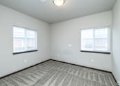 Thumbnail 5 of 13 - A room with carpeted floor and two windows.