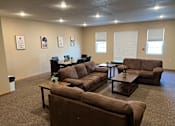 Thumbnail 8 of 12 - a living room with couches and tables at Bluemont Village Apartments, Fargo, 58103
