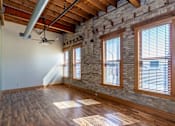 Thumbnail 6 of 16 - A room with wooden floors and a brick wall, Kassenborg Apartments, Moorhead, Minnesota, 56560