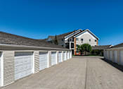 Thumbnail 11 of 12 - A row of white garage doors in front of a house.