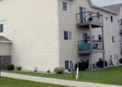 Thumbnail 6 of 6 - A white two story apartment building with a balcony on the second floor.