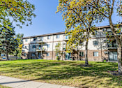 Thumbnail 10 of 10 - A tree with yellow leaves is in front of a building, Pine Pointe Apartments, Fargo, ND.