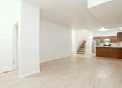 Thumbnail 3 of 10 - A spacious room with wooden floors and white walls.