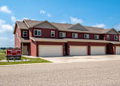 Thumbnail 9 of 10 - a house with two garage doors and a sign in front of it