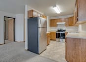 Thumbnail 1 of 9 - A kitchen with a refrigerator, oven, and stove.