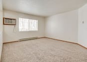 Thumbnail 5 of 9 - A room with a carpeted floor and a window with blinds.