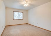 Thumbnail 10 of 11 - A room with a carpeted floor and a ceiling fan at Savanna Apartments, Minnesota, 56303