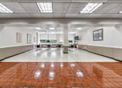 Thumbnail 11 of 13 - a large community room with a table and chairs in the middle of it
