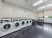 Thumbnail 9 of 13 - a spacious laundry room with washers and dryers and a row of washing machines  at 500 Manila apartments in Jersey City
