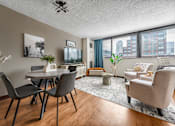 Thumbnail 4 of 13 - A beautiful and spacious living room with a dining table and chairs and a large window with a lot of sun light in apartment in Jersey City NJ