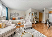 Thumbnail 3 of 13 - Apartment living room with a couch and chairs and a kitchen with a refrigerator in Jersey City