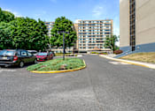 Thumbnail 3 of 25 - a parking lot with cars parked in front of a building