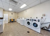 Thumbnail 23 of 25 - a laundry room with washers and dryers and a row of washing machines
