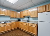 Thumbnail 8 of 15 - A kitchen with wooden cabinets and a white refrigerator.
