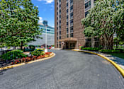 Thumbnail 13 of 15 - A curved driveway leads to a building entrance.