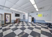 Thumbnail 18 of 22 - a room with a checkered floor and a door to a classroom