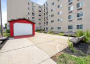 Thumbnail 7 of 22 - an apartment building with a red shed and a white garage door