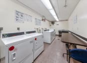 Thumbnail 19 of 22 - a laundry room with washes and dryers and a table