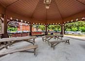 Thumbnail 11 of 25 - a covered pavilion with picnic tables in a park