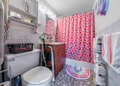Thumbnail 19 of 25 - a small bathroom with a red and white shower curtain